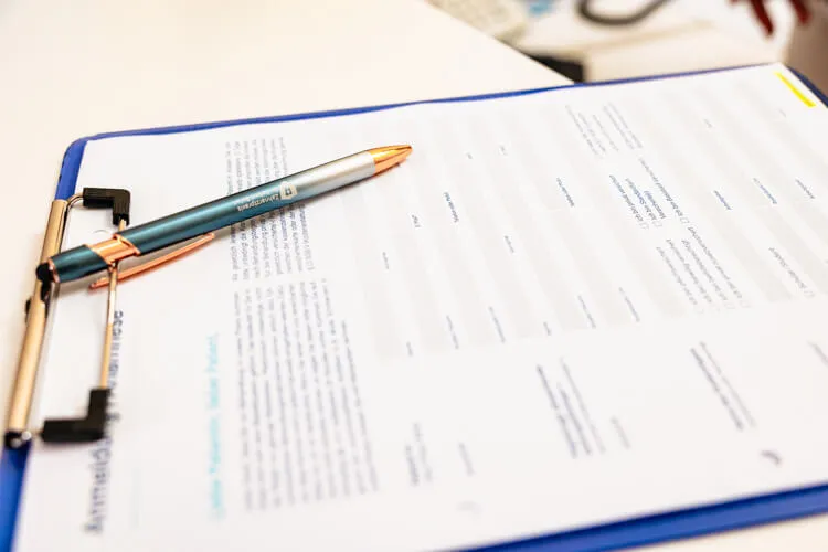 Anamnesebogen der Zahnarztpraxis Dr. Balan mit Kugelschreiber auf Bogen